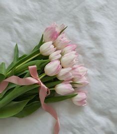 Pink And White Tulips Are Tied Together With A Pink Ribbon On A Bed Sheet