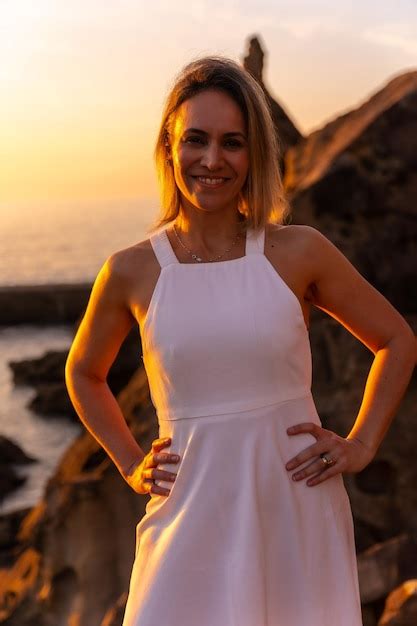 Retrato De Una Mujer Rubia Con Un Vestido Blanco Al Atardecer Junto A