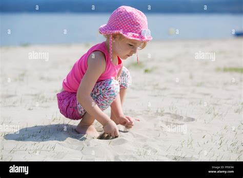 Junge blonde Mädchen spielen im Sand am Strand Stockfotografie Alamy