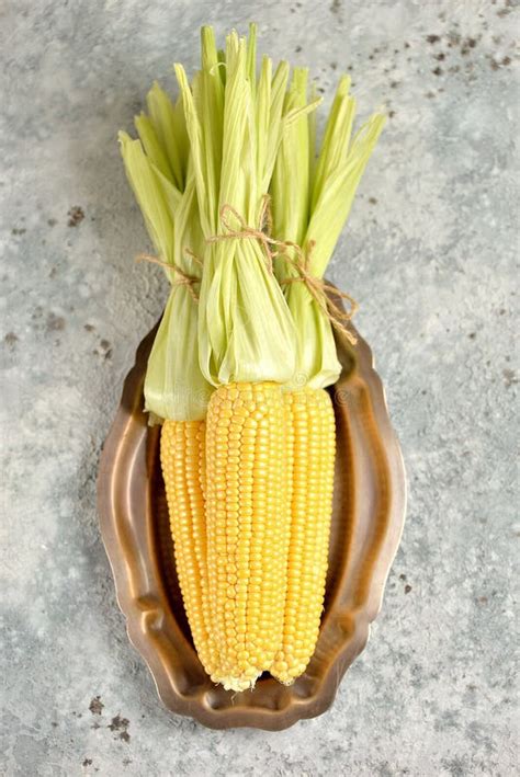 Fresh Organic Sweet Corn With Green Leaves On A Light Background Stock