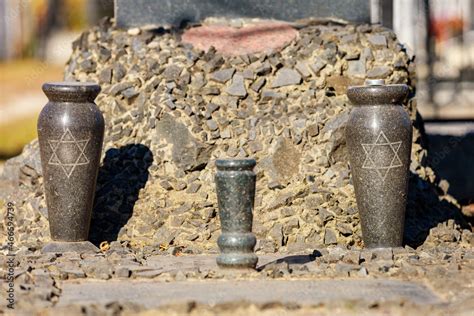 A gravestone with traditional Jewish symbols in the Jewish cemetery ...