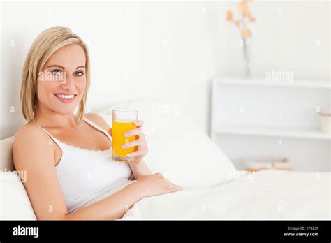 Blonde Woman Drinking Orange Juice Stock Photo Alamy
