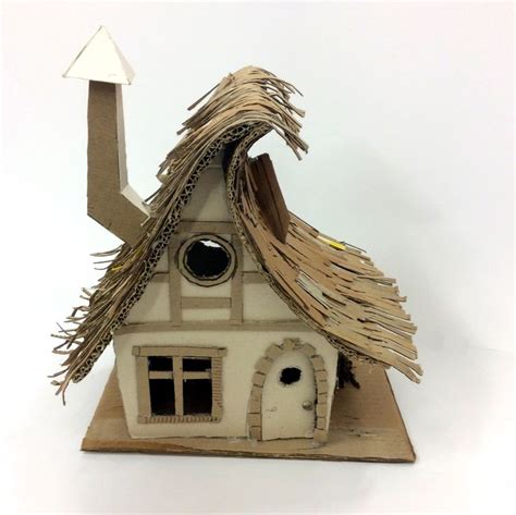 A Small House Made Out Of Cardboard With A Roof That Has A Wind