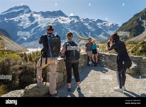 Tourists Taking Photos On The Hooker Valley Track With A Backdrop Of