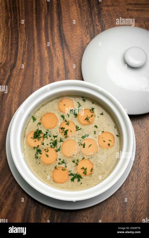 German Traditional KARTOFFELSUPPE Potato And Sausage Soup On Wood Table