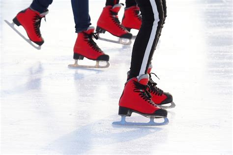 Pies De Diferentes Personas Patinando En La Pista De Hielo Foto Premium