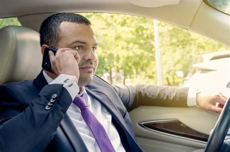 Premium Photo | Businessman talking on the phone while driving in a ...