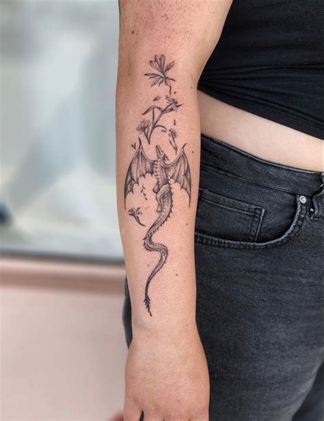 A Woman S Arm With A Dragon Tattoo On The Left Side Of Her Body