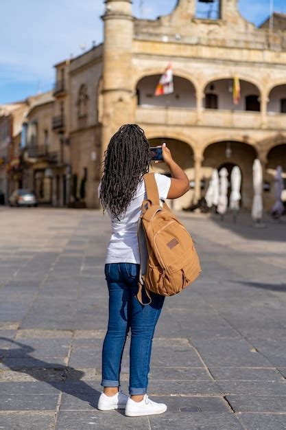 Mujer turista de vacaciones tomando fotos con teléfono en el famoso