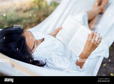 Une Brunette Femelle Est Situ E Dans Un Hamac L Ext Rieur Et Lit Un Livre Une Jeune Femme