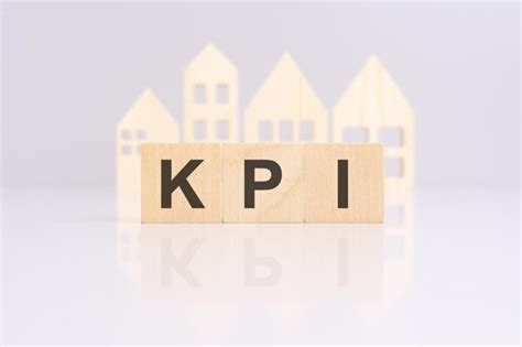 Premium Photo | KPI text made of wooden cubes with a small wooden model ...