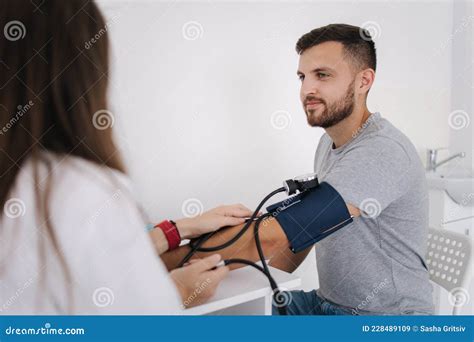 Young Man With High Blood Pressure Female Doctor Using