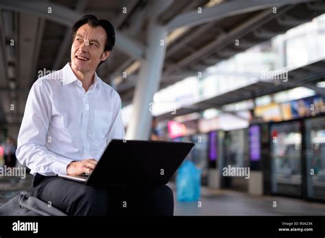 Mature Handsome Businessman Using Laptop Computer In Train Station Stock Photo Alamy