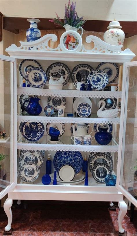 A White China Cabinet With Blue And White Plates On It S Shelves In A Room