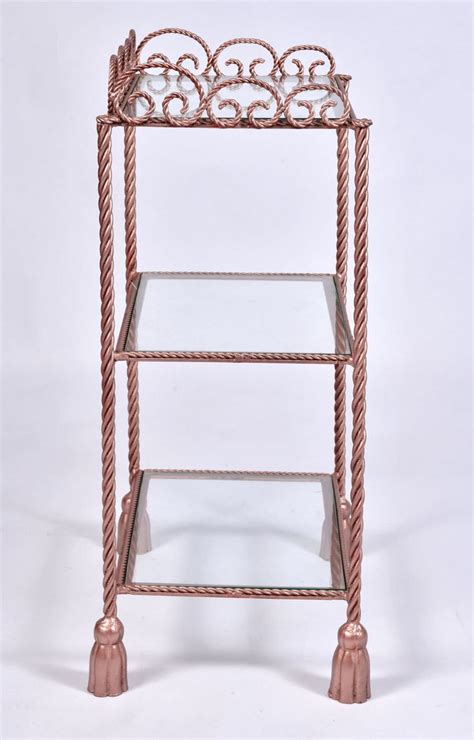 A Three Tiered Metal Shelf With Glass Shelves