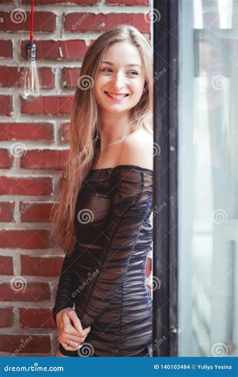 Muchacha Hermosa En Un Vestido De Noche Que Presenta Contra Una Pared