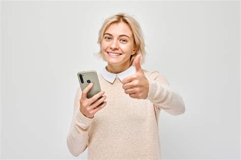 Portrait D une Jeune Femme Blonde Tenant Un Téléphone Portable Dans La Main Avec Un Visage