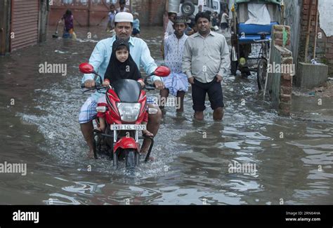 150711 KOLKATA Indian Commuters Pass Through A Water Logged