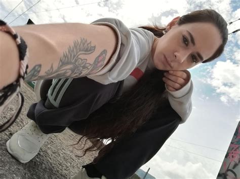 Premium Photo Portrait Of Mature Woman Crouching On Road Against Sky