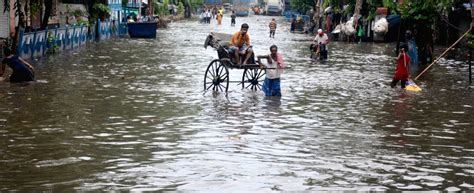 Kolkata A Rickshaw Puller Wade Through A Waterlogged Street After