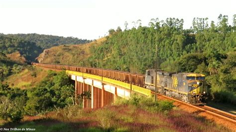 Trem carregado de minério a locomotiva SD70ACe na cauda passando na