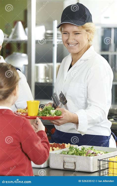 Female Pupil In School Cafeteria Being Served Lunch By Dinner La Stock