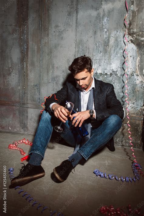 Drunk Man Sitting On The Floor With Alcohol At Christmas After Party