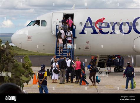 tourists departing on AeroGal flight at Seymour airport, Baltra Island, Galapagos Islands ...