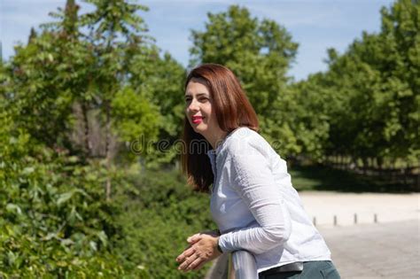 Red Haired Mature Woman Leaning On A Railing Contemplating The Landscape With A Serene