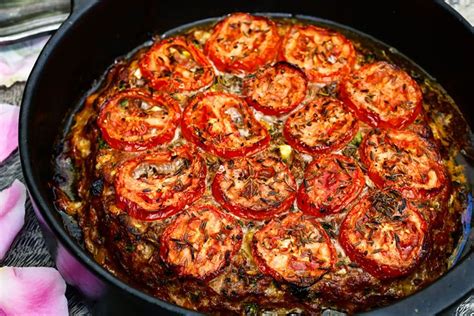 A Pan Filled With Cooked Tomatoes On Top Of A Table Next To Pink