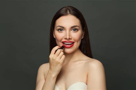 Premium Photo Lovely Woman Applying Red Lipstick On Lips On Black