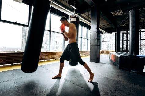 Premium Photo Guy In Red Boxing Gloves With A Naked Torso Dressed In The Black Shorts Hits