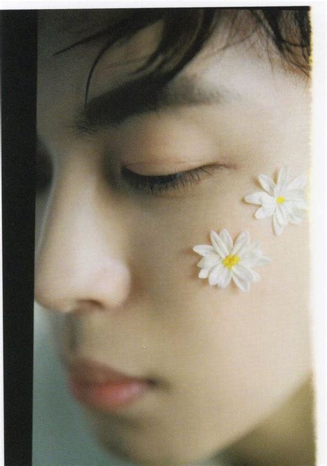 A Close Up Of A Person With Flowers On Their Forehead And Eyes Behind