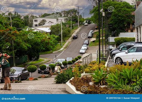 Brisbane Australia Suburban Neighborhood With Men Trimming Grass And