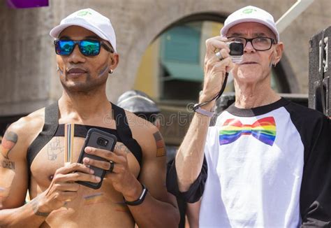 A Muscled Man And An Older Genlteman Attending The Gay Pride Parade Also Known As Christopher