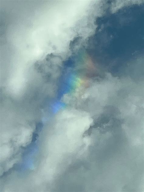 a rainbow appears in the sky above some clouds