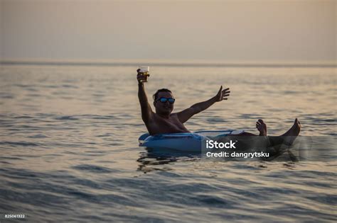 Man With A Raised Hands Smile And Enjoy Summer On Rubber Ring In The