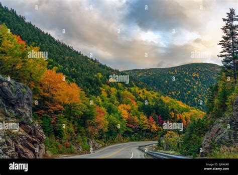 A Two Lane Highway Winds Through Colorful Autumn Foliage At Crawfords