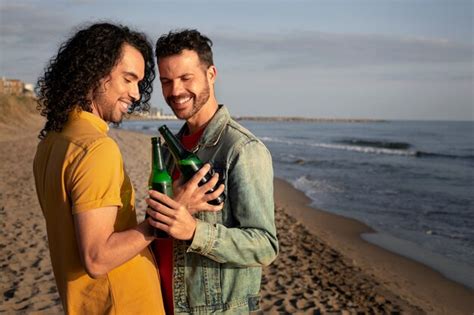 Vista do casal gay sendo carinhoso e passando tempo juntos na praia Foto Grátis