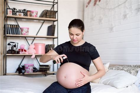 Pregnant Woman Applying Cream on a Belly. Pregnancy Cream on a Woman Belly Pregnant. Stock Photo ...