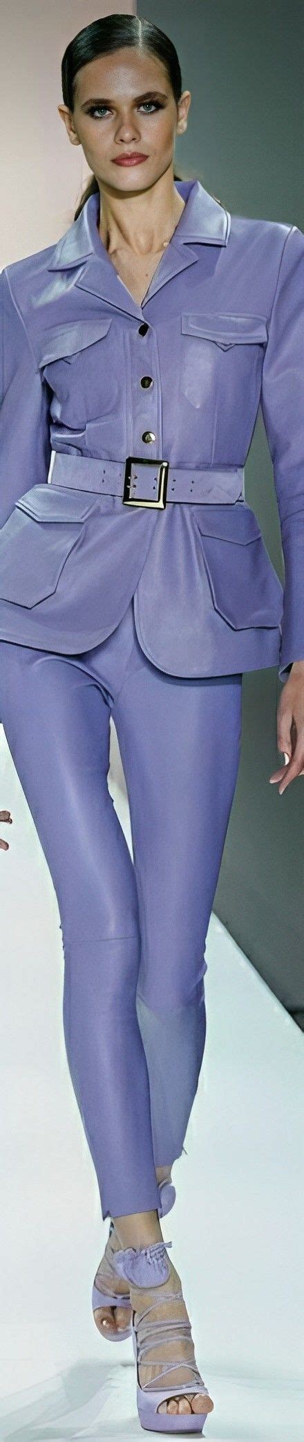 A Woman Is Walking Down The Runway In Purple