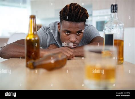 man staring across table at glass of alcohol Stock Photo - Alamy