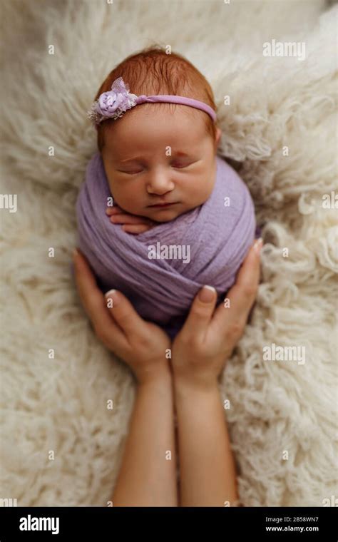 Newborn Baby Girl Is Sleeping In A Cocoon Pose Potato Bag In His