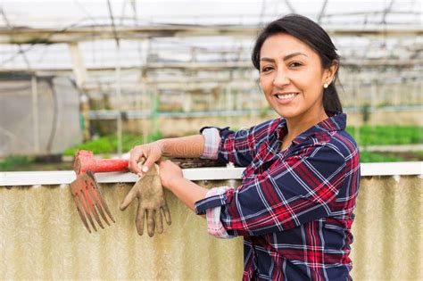 Portrait of a Smiling Female Farmer on the Background of a Greenhouse ...