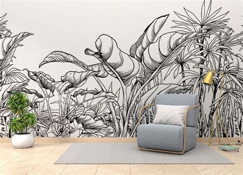 a living room with a chair, plant and wall mural in black and white colors