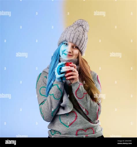 Cute Teenage Girl Wearing Gray Woolen Cap And Scarf Warming Her Hands On A Cup Of Hot Tea