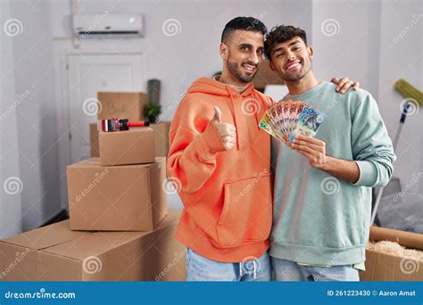 Pareja Joven Hispana Gay Que Se Muda A Una Nueva Casa Con Billetes Sonrientes Alegres Y