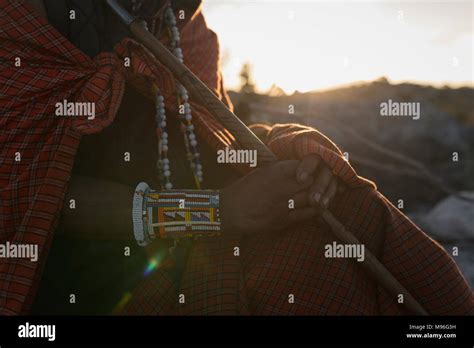 Maasai Man In Traditional Clothing Sitting With Stick Stock Photo Alamy