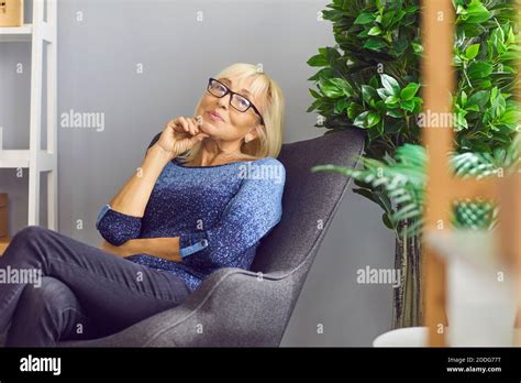 Femme mature assise dans un fauteuil Banque de photographies et dimages à haute résolution Alamy