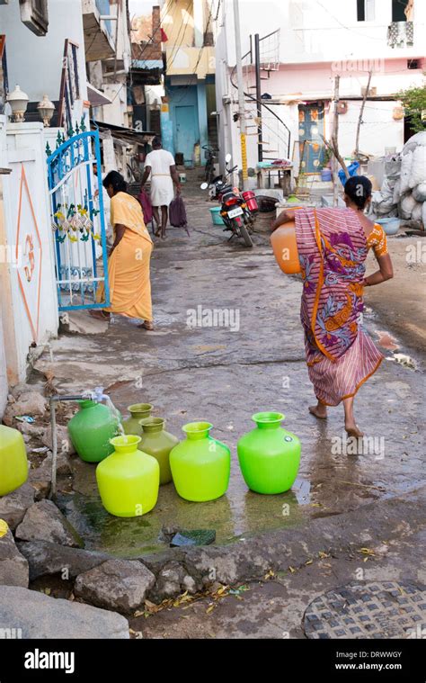 Indian Women Filling Plastic Pots With Water From A Standpipe In A